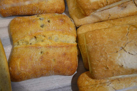 Different kinds of bread rolls on on baking paper from above. Kitchen or bakery poster design.の写真素材