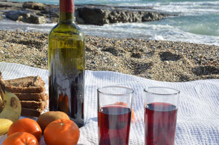 A party on the beach at sunset with wine. Romantic day evening in the summer by the sea. Picnic. copy space,の写真素材
