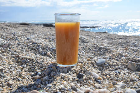 summer orange juice against the sea on the shore. concept of rest, travel, relax, ecologyの写真素材