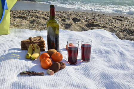 A party on the beach at sunset with wine. Romantic day evening in the summer by the sea. Picnic. copy space,の写真素材