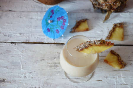 Traditional caribbean cocktail pina colada in a glasses on a blue background. Cocktail or juice with...