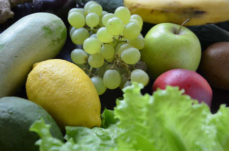 Healthy food clean eating selection: fruit, vegetable, seeds, superfood, cereal, leaf vegetable on gray concrete backgroundの写真素材