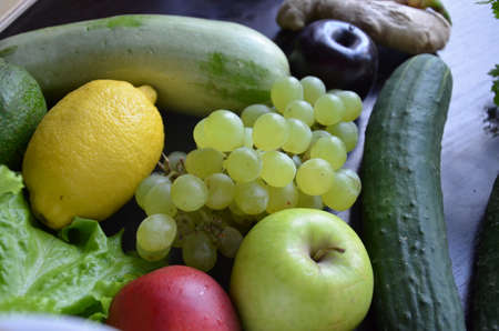 Healthy food clean eating selection: fruit, vegetable, seeds, superfood, cereal, leaf vegetable on gray concrete backgroundの写真素材