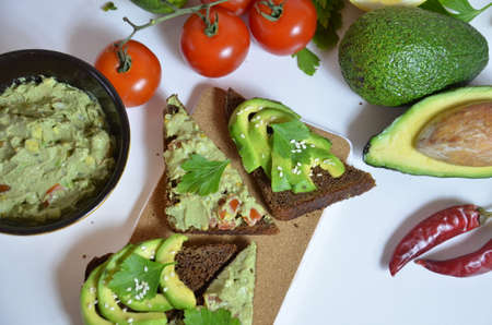 Guacamole and bread. Toast with avocado on white background. Homemade Mexican healthy vegan foodの写真素材