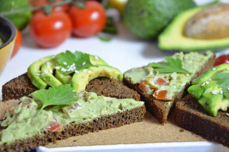 Guacamole and bread. Toast with avocado on white background. Homemade Mexican healthy vegan foodの写真素材