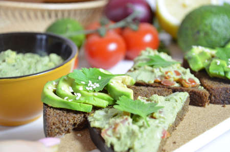 Guacamole and bread. Toast with avocado on white background. Homemade Mexican healthy vegan foodの写真素材