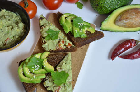 Guacamole and bread. Toast with avocado on white background. Homemade Mexican healthy vegan foodの写真素材