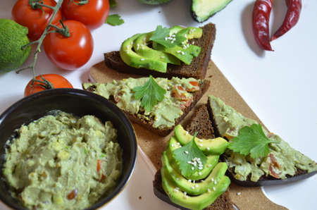 Guacamole and bread. Toast with avocado on white background. Homemade Mexican healthy vegan foodの写真素材