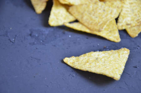 Mexican corn chips nachos with salsa dip on a black background with guacamole sauce, avacoda with lime and hot pepper tamato.の写真素材