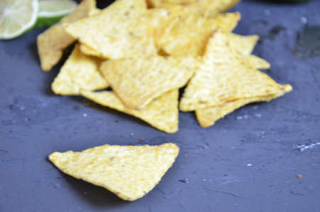 Mexican corn chips nachos with salsa dip on a black background with guacamole sauce, avacoda with lime and hot pepper tamato.の写真素材