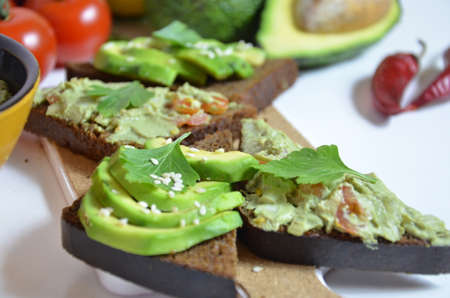 Guacamole and bread. Toast with avocado on white background. Homemade Mexican healthy vegan foodの写真素材