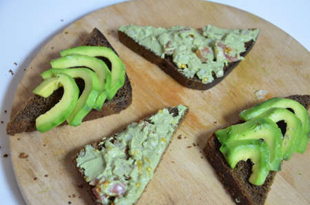 A delicious Bowl of Guacamole next to fresh ingredients on a table with tortilla chips and salsa. sandwich with guacamole, red hot pepper, lime, lemon, avocado.の写真素材
