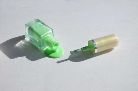 spilled colored nail polish bottle on white background copy space top view.の写真素材