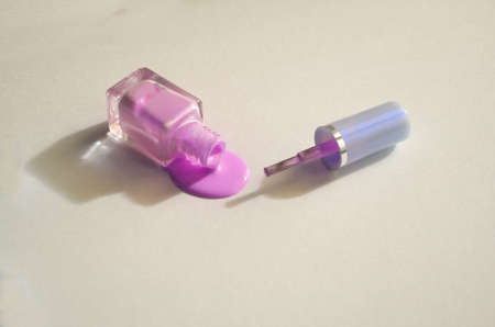spilled colored nail polish bottle on white background copy space top view.の写真素材
