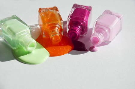 Bottles with spilled nail polish over white background.の写真素材