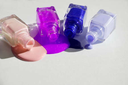 Bottles with spilled nail polish over white background.の写真素材