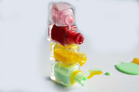 Bottles with spilled nail polish over white background.の写真素材