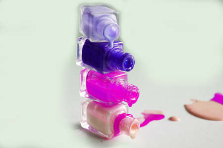 Bottles with spilled nail polish over white background.の写真素材
