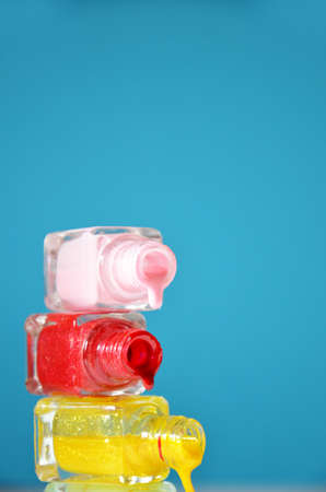 Bottles with spilled nail polish over blue background. The concept of fashion, beauty, women's care. manicure. beauty saloon. spaの写真素材