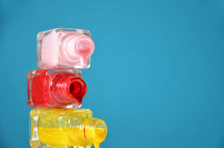 Bottles with spilled nail polish over blue background. The concept of fashion, beauty, women's care. manicure. beauty saloon. spaの写真素材