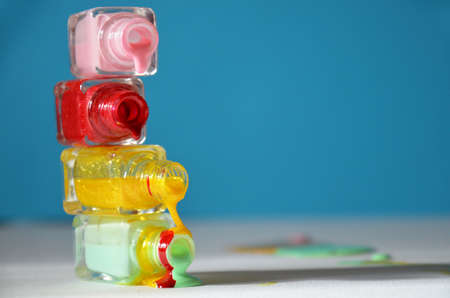 Bottles with spilled nail polish over blue background. The concept of fashion, beauty, women's care. manicure. beauty saloon. spaの写真素材