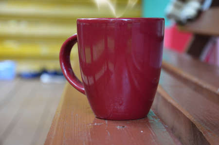 A cup with a hot drink tea or coffee on the street. steam from a cup. Hot tea cup on a utumn or winter day window background.の写真素材
