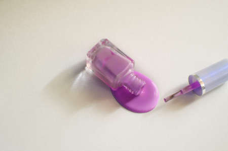 spilled colored nail polish bottle on white background copy space top view.の写真素材