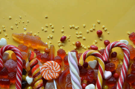 An assortment of colourful, festive sweets, blue marmalade in the shape of a heart on a blue background with a variety of caramels and candies, marshmallows. Abstract background. top view copy space.の写真素材