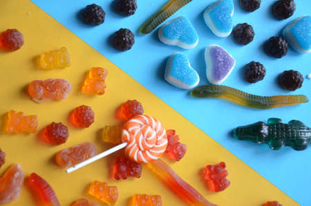 An assortment of colourful, festive sweets, blue marmalade in the shape of a heart on a blue...