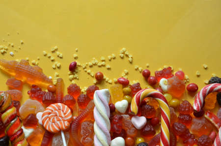 An assortment of colourful, festive sweets, blue marmalade in the shape of a heart on a blue background with a variety of caramels and candies, marshmallows. Abstract background. top view copy space.の写真素材