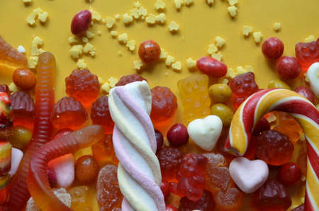 An assortment of colourful, festive sweets, blue marmalade in the shape of a heart on a blue background with a variety of caramels and candies, marshmallows. Abstract background. top view copy space.の写真素材