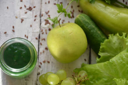 Detox diet. Green smoothie with different vegetables on wooden background copy space. diet vegitarians healthy low calorie food. salad, greens, green apple chia or flax linen seedsの写真素材
