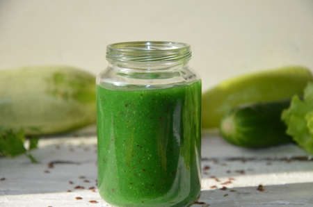 Detox diet. Green smoothie with different vegetables on wooden background copy space. diet vegitarians healthy low calorie food. salad, greens, green apple chia or flax linen seedsの写真素材