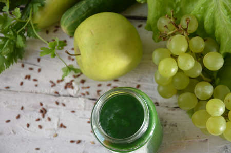Detox diet. Green smoothie with different vegetables on wooden background copy space. diet vegitarians healthy low calorie food. salad, greens, green apple chia or flax linen seedsの写真素材