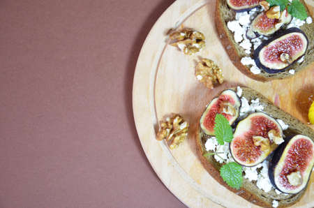 Sandwiches with ricotta, fresh figs, walnuts and honey. Canape or crostini with toasted baguette, cheese, jam, Delicious appetizer, ideal as an aperitif. Selective focusの写真素材