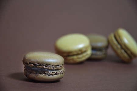 Colourful tasty macaroons in a row. macaroons of different colors on a brown background.の写真素材