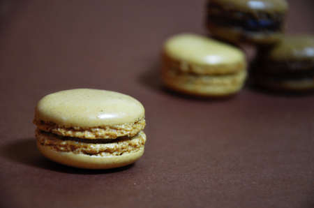 Colourful tasty macaroons in a row. macaroons of different colors on a brown background.の写真素材