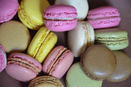 Colourful tasty macaroons in a row. macaroons of different colors on a brown background.の写真素材