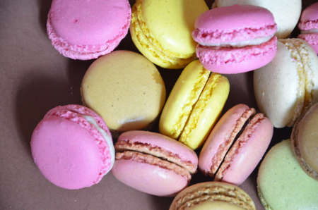 Colourful tasty macaroons in a row. macaroons of different colors on a brown background.の写真素材