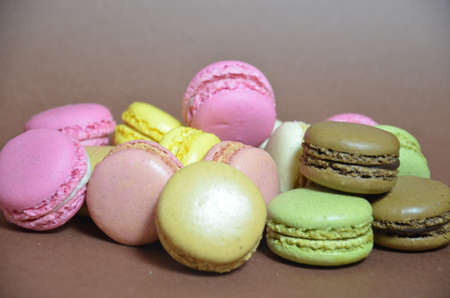 Colourful tasty macaroons in a row. macaroons of different colors on a brown background.の写真素材