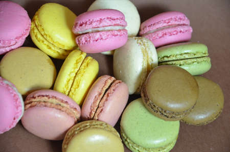 Colourful tasty macaroons in a row. macaroons of different colors on a brown background.の写真素材