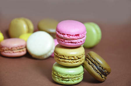 Colourful tasty macaroons in a row. macaroons of different colors on a brown background.の写真素材