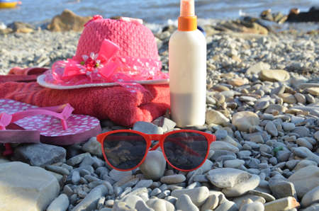 Beach items for resort flat lay. Top view, things for swimming and relaxation, sunbathing on the beach on the beach. Large, etched raspberry hat, towel, sunglasses, sunblock.の写真素材