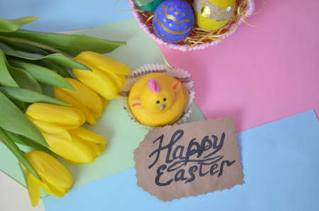 Easter, Easter egg color vibrant, spring Orthodox holiday. colorful decorated eggs in a pink basket on a background of different colors. inscription happy easter, gift, chicken, yellow tulips.の写真素材