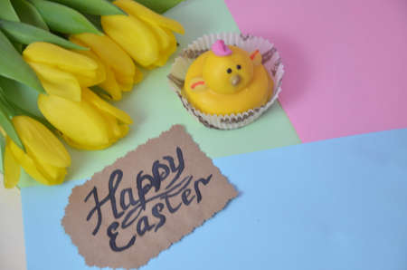 Easter, Easter egg color vibrant, spring Orthodox holiday. colorful decorated eggs in a pink basket on a background of different colors. inscription happy easter, gift, chicken, yellow tulips.の写真素材