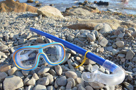 Diving. Mask and snorkel for scuba diving are on the seashore, the beach is stone. Diving with a mask. Diving. Hobby. Leisure. Tourismの写真素材