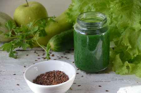 Detox diet. Green smoothie with different vegetables on wooden background copy space. diet vegitarians healthy low calorie food. salad, greens, green apple chia or flax linen seedsの写真素材