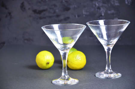 two empty glasses for making margarita cocktails with lime on a black background Margarita cocktails shot on a bar counter in a nightclub.の写真素材
