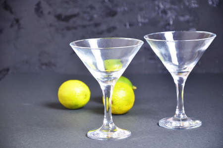 two empty glasses for making margarita cocktails with lime on a black background Margarita cocktails shot on a bar counter in a nightclub.の写真素材
