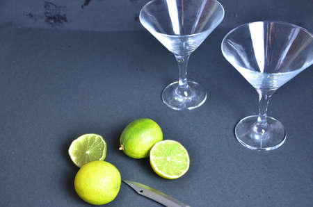 two empty glasses for making margarita cocktails with lime on a black background Margarita cocktails shot on a bar counter in a nightclub.の写真素材